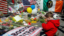 A child at the Boston Bombings Memorial. Jim Bourg / Reuters 
Matthew DeLuca, “Boston observes moment of silence one week after bombing,” NBC News, April 22, 2013. Accessed July 1, 2013. Retrieved from
http://usnews.nbcnews.com/_news/2013/04/22/17861457-boston-observes-moment-of-silence-one-week-after-bombings?lite