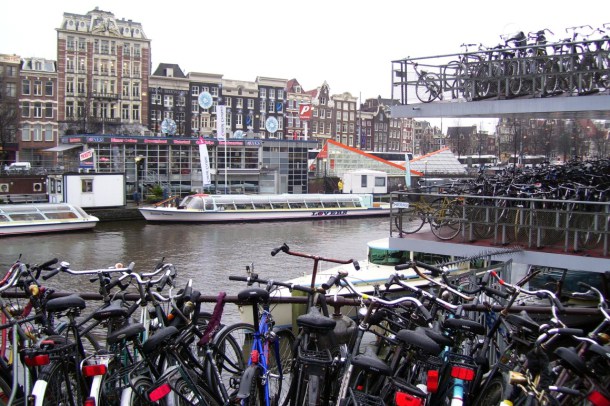 Parked bikes packed together outside of the main bicycle parking facility near Amsterdam’s Central Station. The parking facility is used well beyond its capacity. Source: Wikipedia Commons.
